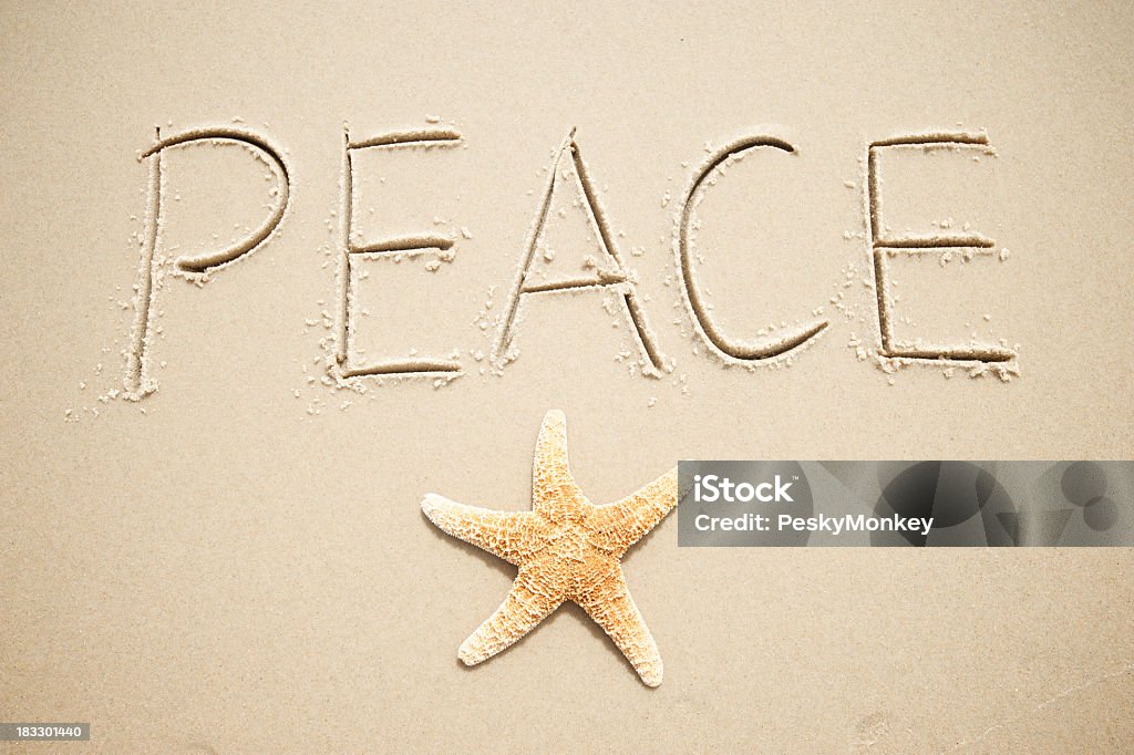 Inspirador mensaje de felicitación de vacaciones de paz escrito a mano estrella de mar en la arena - Foto de stock de Arena libre de derechos