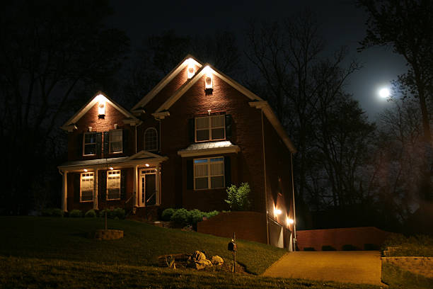 istock House at night with lights and moon shining 183301495
