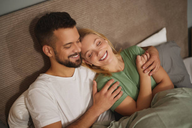 istock Lovely couple cuddling in their bed at home 1833020039