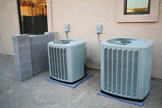 Air Conditioner Pair A couple of brand new air conditioners sitting next to a new home. The block wall to the left of them has not been finished yet. These are Crane Air Conditioners. air pump stock pictures, royalty-free photos & images