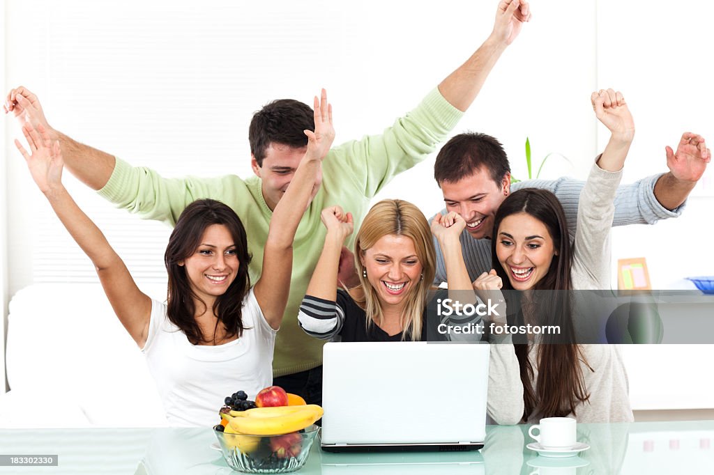 Alegre grupo de pessoas que trabalham no computador portátil com as mãos levantadas - Royalty-free Adolescente Foto de stock