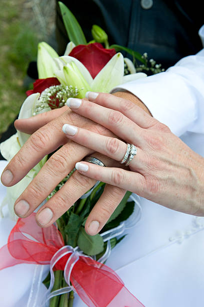 istock Newlyweds looking at their rings over flowers 183303167