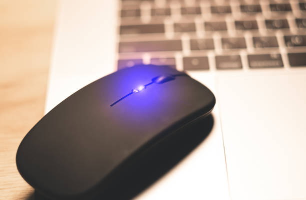 istock Black wireless minimalist mouse near the gray laptop . Modern technology device. 1833032586