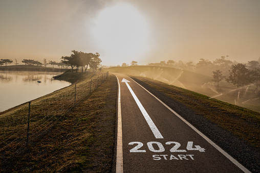 Happy new year 2024,2024 symbolizes the start of the new year. The letter start new year 2024 on the road in the nature route roadway have tree environment ecology or greenery wallpaper concept.