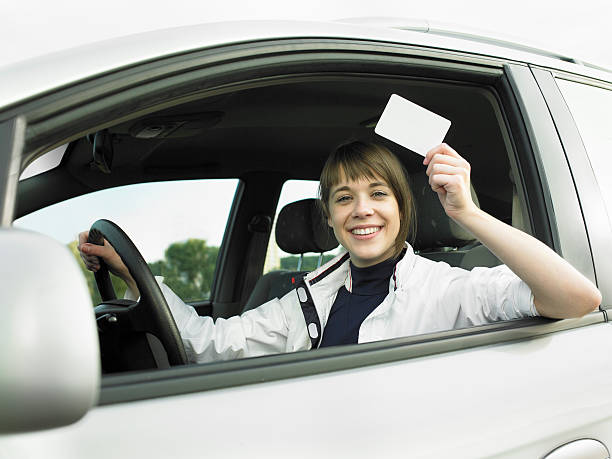 mujer joven en el coche y sosteniendo una tarjeta en blanco - smiling business card horizontal women fotografías e imágenes de stock