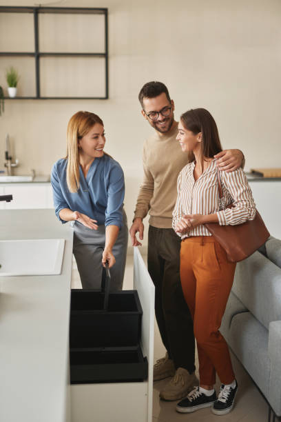 istock Female shop assistant helping young couple choose new garbage bin 1833040656