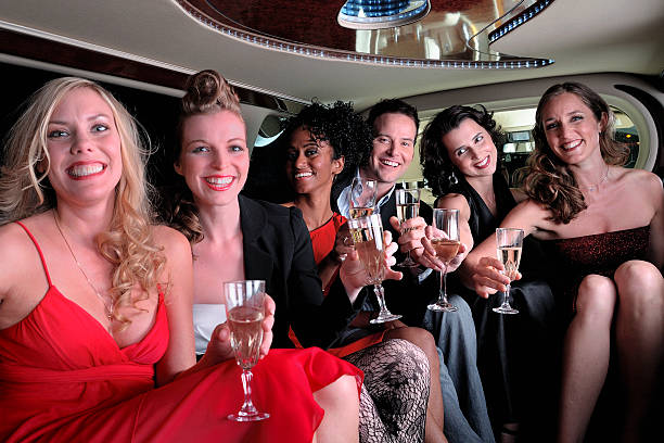 istock Group  in  a limousine  having drinks on  way   to party 183305160