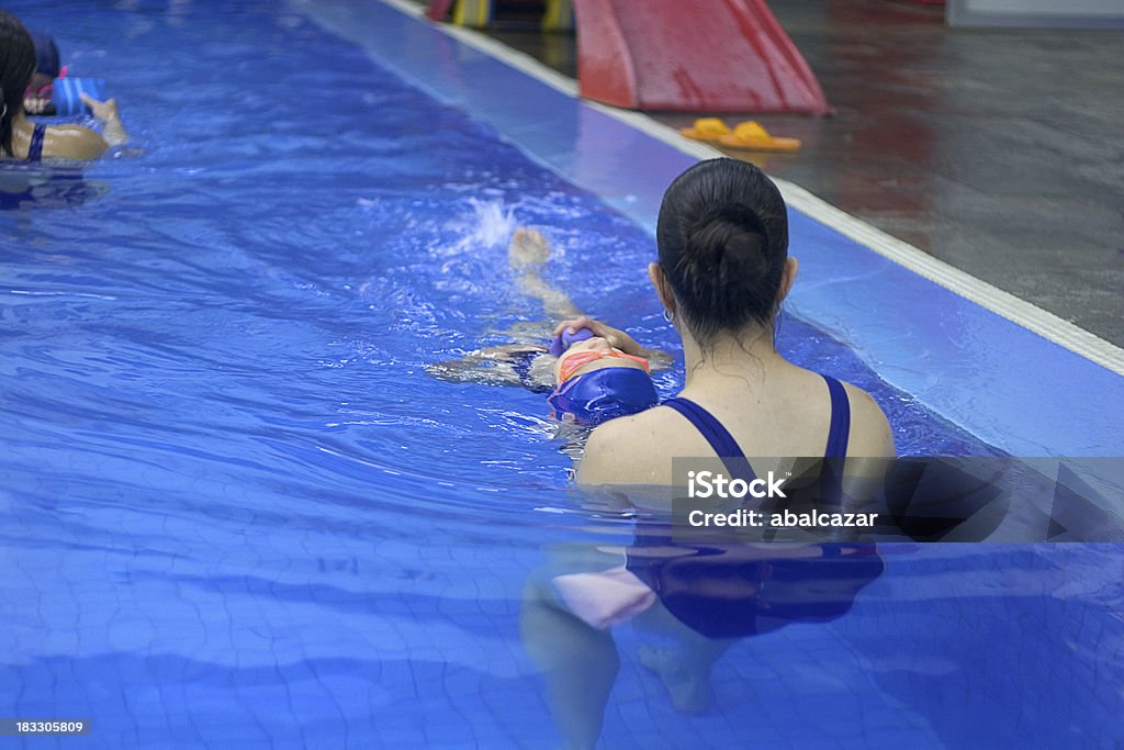 learning to swim young girl taking swimming lessons with an instructorother similar images Beauty Stock Photo