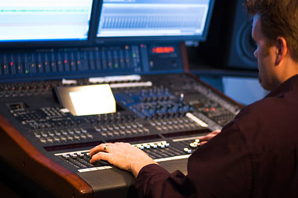 Man at a studio control moving buttons up and down stock photo