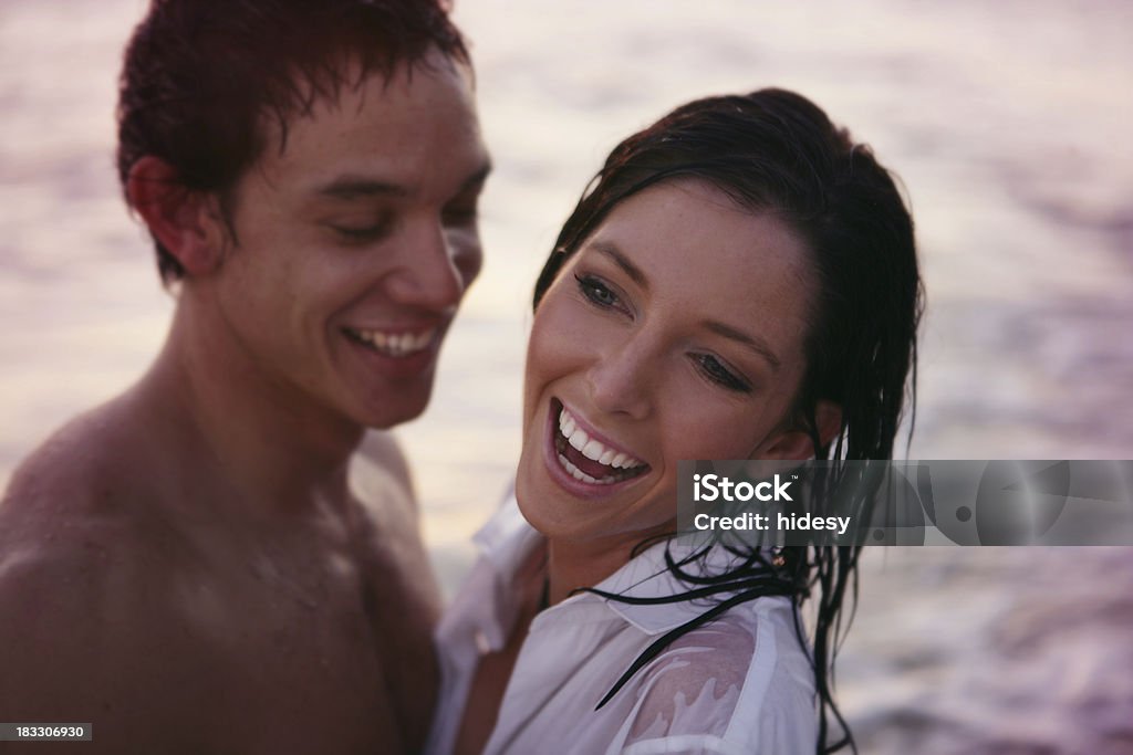 Sunset Laughter Woman and guy laughing at the beach.  Slightly dark. 20-29 Years Stock Photo