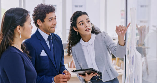 istock Business people, teamwork and planning on glass board for data analytics, marketing research and strategy in office. Professional manager, woman or employees with ideas, brainstorming and tablet 1833078047