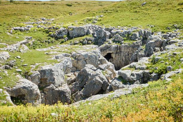 istock Cave or grotto, view from the outside. Mountainous terrain. Rocks and vegetation. 1833092203