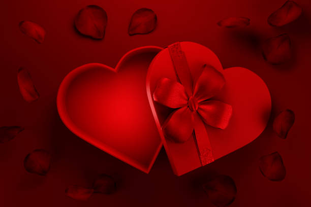 istock Heart shaped gift box with rose petals on red background. 1833110419