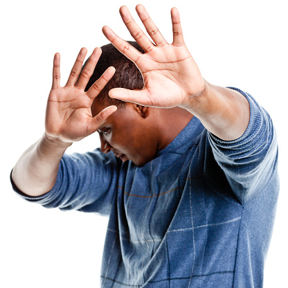 A young african-american man puts his hands up and turns away from the camera. http://s3.amazonaws.com/drbimages/m/niccli.jpg