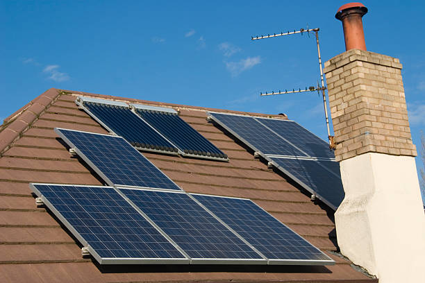 istock Solar Panels and Water Heaters on a tiled roof 183312262