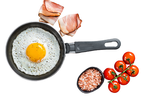 Fried egg in a frying pan with tomatoes and bacon Isolated, white background