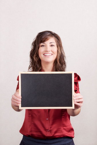 Brunet woman holding a blank chalk board.