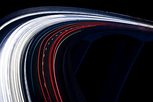traffic light trails, highway viaduct at night from a high angle view, blurred motion