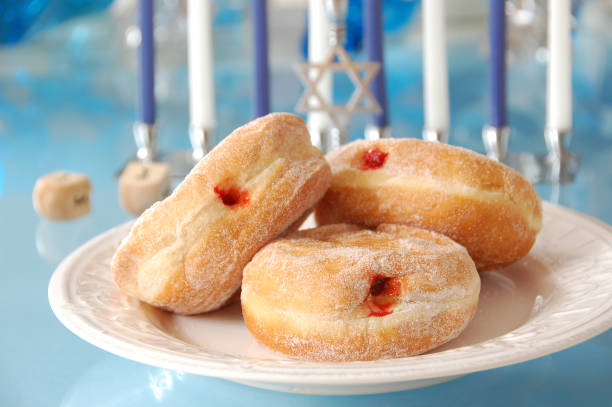 "Sufganiyot, deep-fried donuts filled with jelly, with other symbols of Hanukkah in the background.More Hannukah images:"