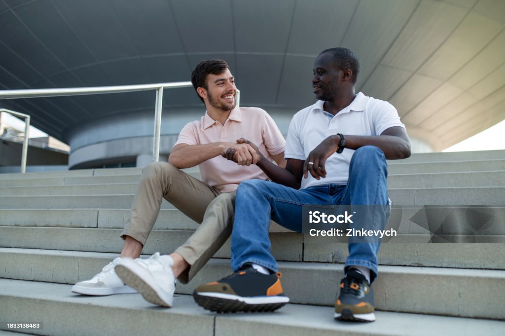 Two People Getting Steps In Two Colleagues Sitting Together On Steps And Talking Stock Photo ...