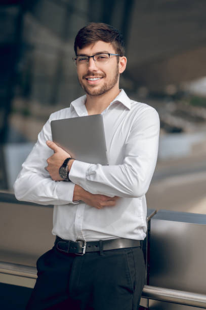istock Young male manager with a laptop looking contented 1833140631