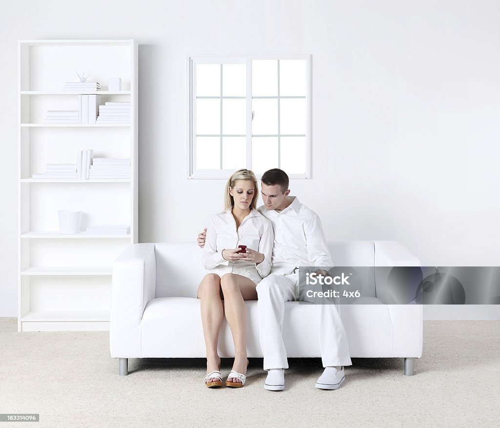 Casal em casa brincando com todos brancos cellphone - Royalty-free Adulto Foto de stock