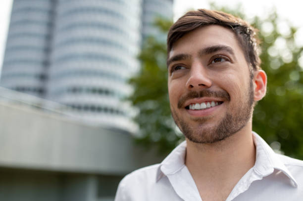 istock Young dark-haired man in white shirt smiling a d feeling joyful 1833141144