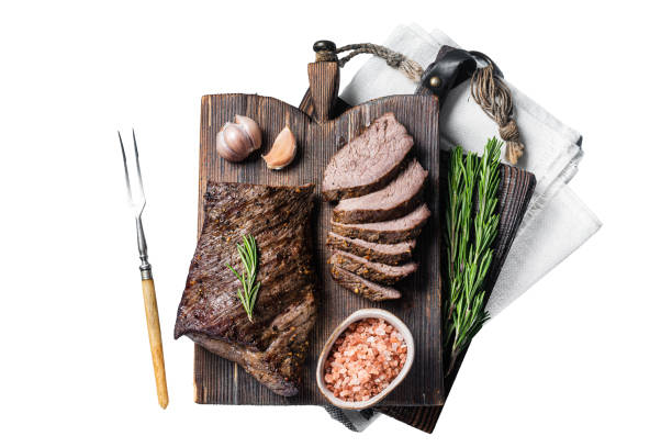 istock Roast and sliced tri tip beef steak on a wooden board with herbs. Isolated, white background. 1833142222