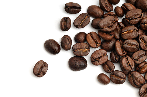 Roast Coffee Beans Scattered across a white background.