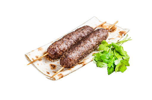 Traditional middle east kefta, kofta kebab from ground beef and lamb meat grilled on skewers served with flatbread and onion.  Isolated, white background