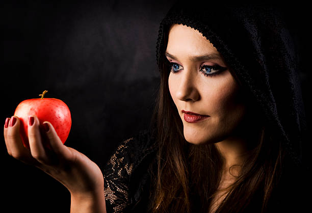 istock Attractive female with black costume holding a red apple 183314575