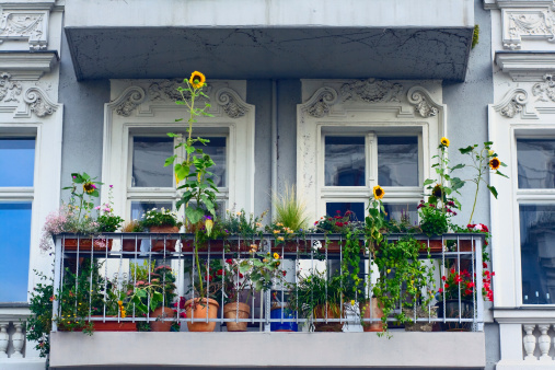 Balconies decorated with flower pots, cast iron railings, stone columns, retro style street light, Bierzo area, León province, Castilla y Leon, Spain.