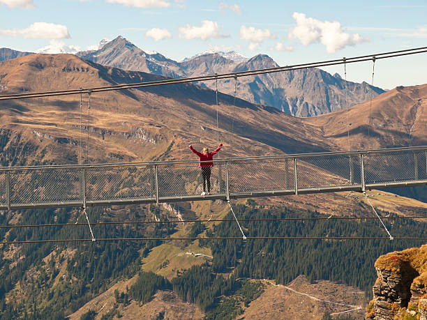 istock A woman standing on a suspension bridge 183315890