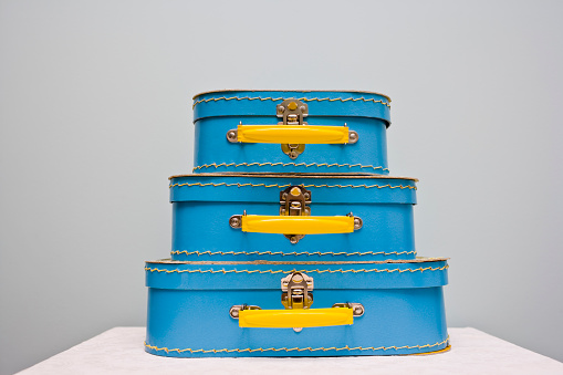 Set of three identical suitcases in varying sizes one of top of the other in a stack