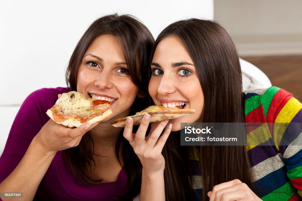 Две молодые женщины, ест пицца - Стоковые фото В помещении роялти-фри