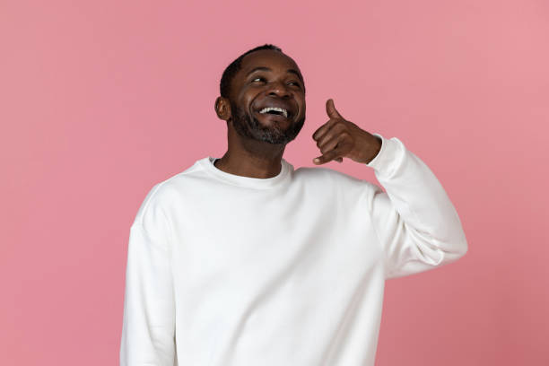 istock Happy black man wearing white sweatshirt showing call me back sign 1833172567