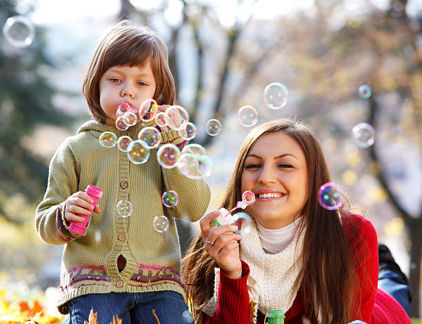 istock Mother and child blowing bubbles in nature 183317331