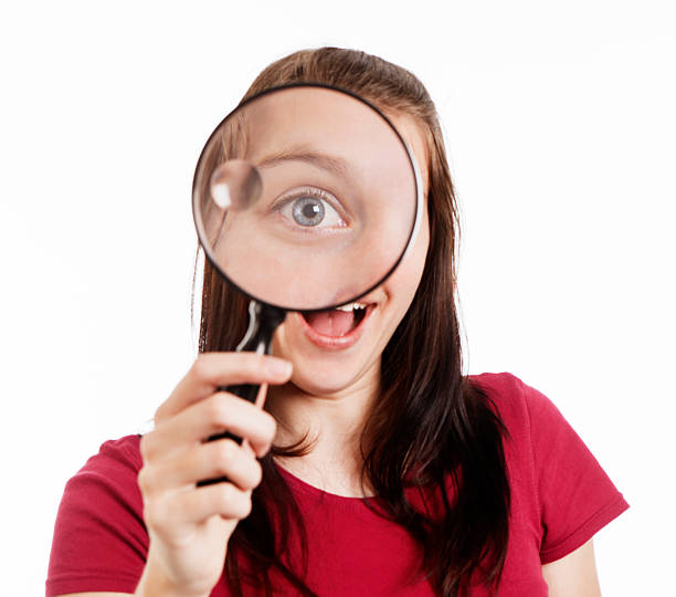 istock Pretty brunette looks through magnifying glass showing a big eye 183317349
