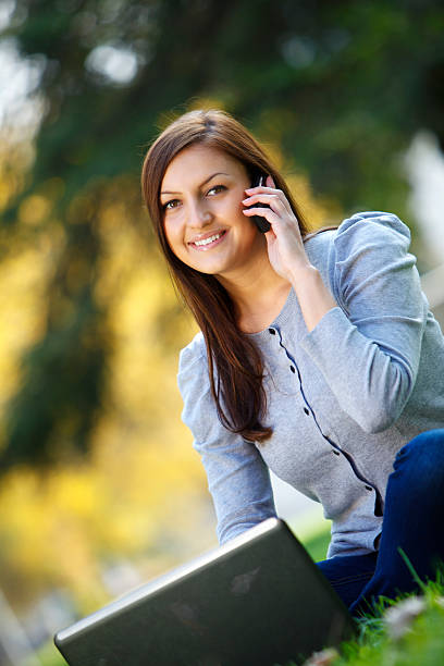 istock Young woman in nature using cell phone 183318418