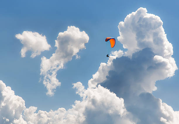 Paraglider sport parachute flying dramatic clouds stock photo