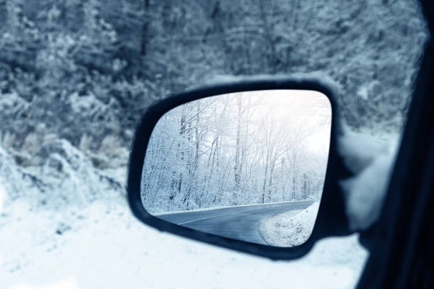 zimowa droga odbija się w lusterku wstecznym samochodu - rear view winter blizzard nordic countries zdjęcia i obrazy z banku zdjęć