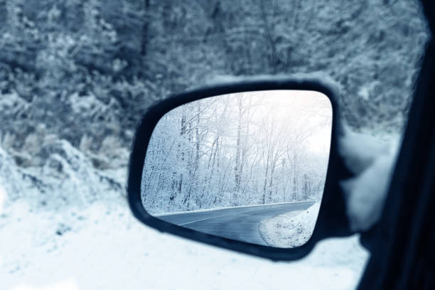 a estrada de inverno é refletida no espelho retrovisor do carro - rear view winter blizzard nordic countries - fotografias e filmes do acervo