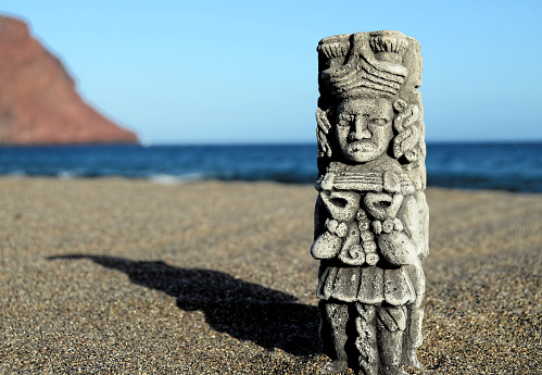Ancient Maya Statue on the Sand Beach near the Ocean