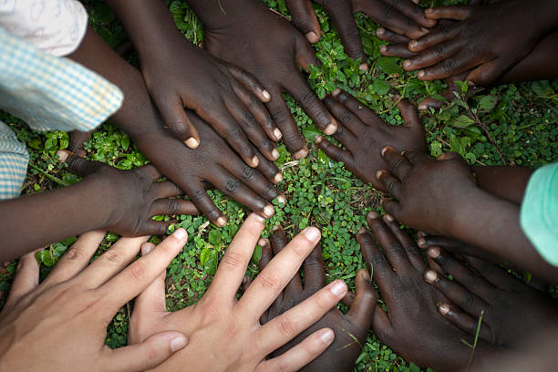 istock Hands of african children and one white hand 183318577