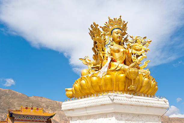 Golden Kwan-yin statue under blue sky