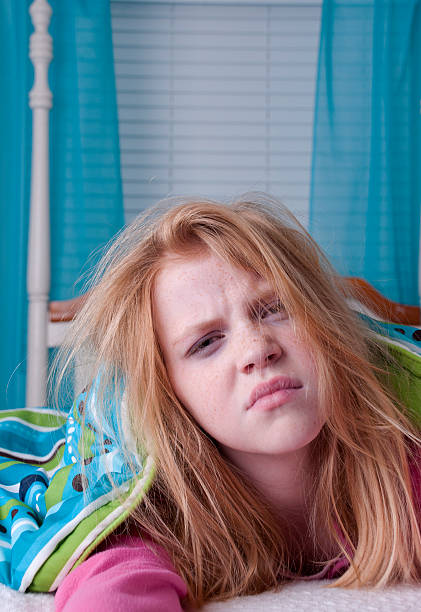 Unhappy girl waking up with bed head stock photo