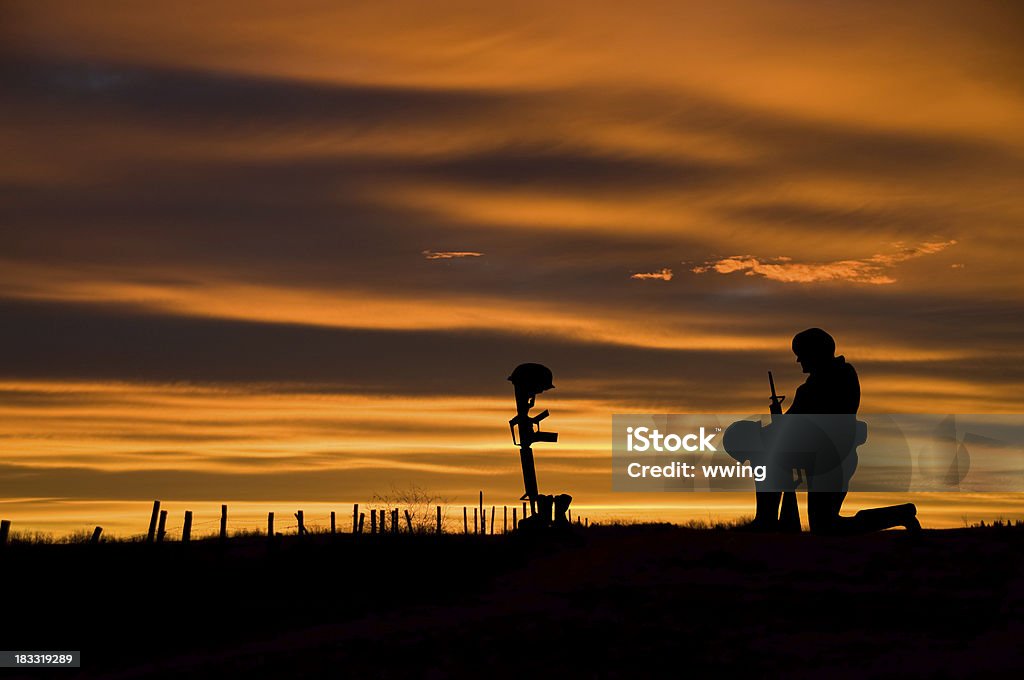 Fallen Soldier The battlefield grave of a fallen soldier with another soldier kneeling before it. Copy space World War I Stock Photo