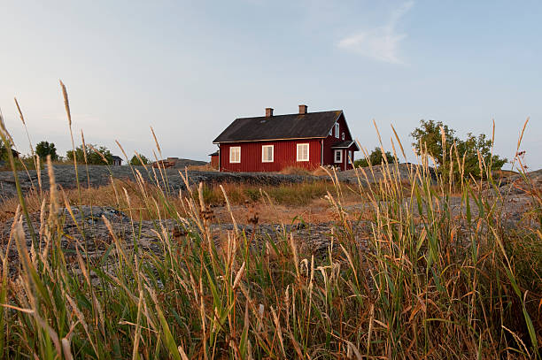 夕暮れの群島 - red cottage small house ストックフォトと画像