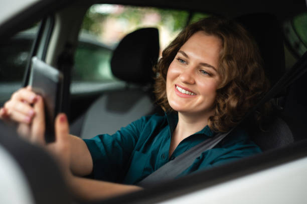 istock Woman driver sitting in car and looking at smartphone screen. 1833207499