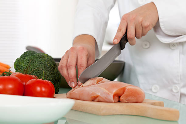 Chef cutting chicken breast stock photo
